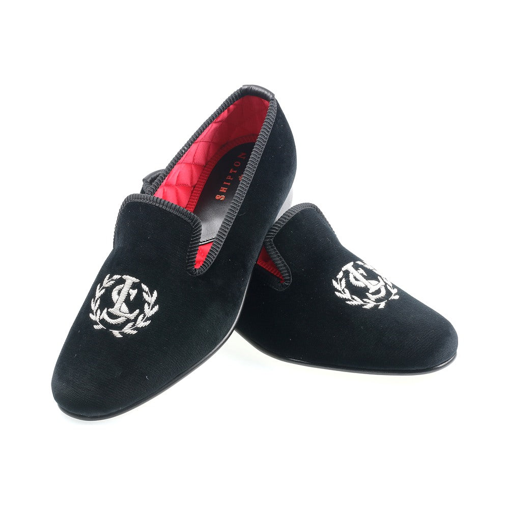The Albert slipper in black velvet, a silver monogram in a laurel wreath embroidered on the vamp.